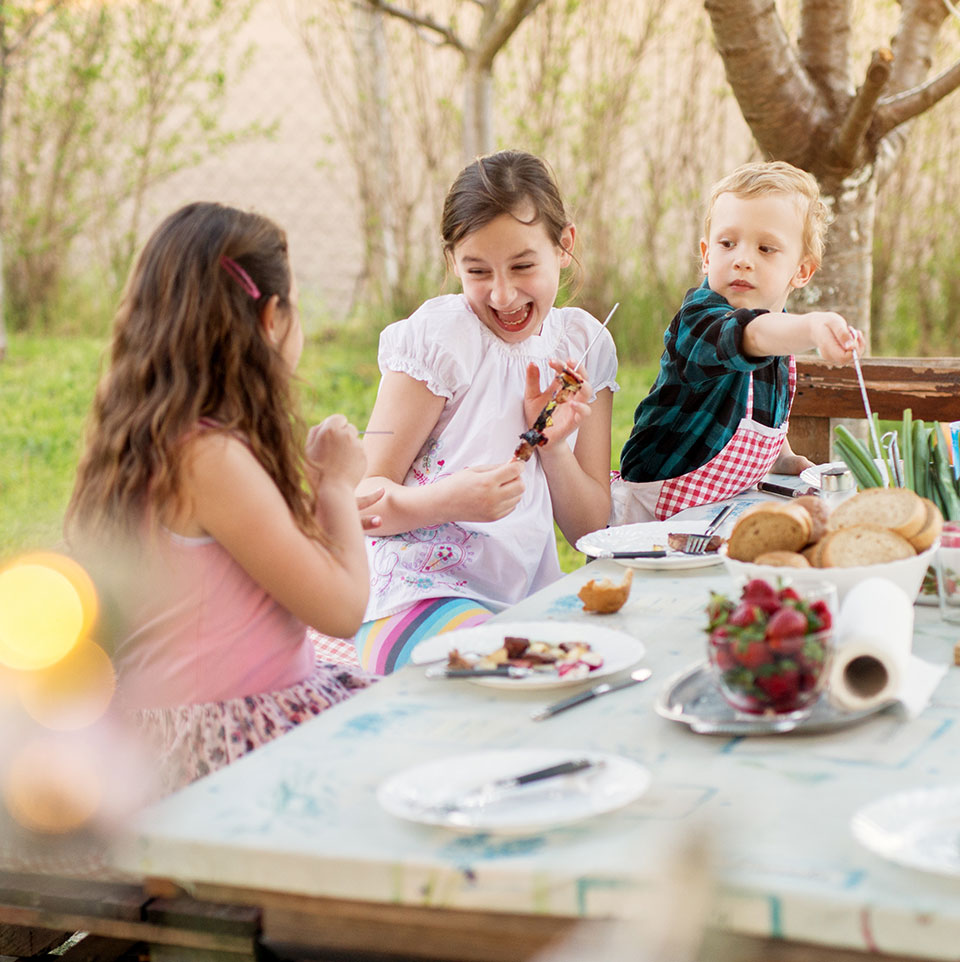 kids eating lunch on picnic table